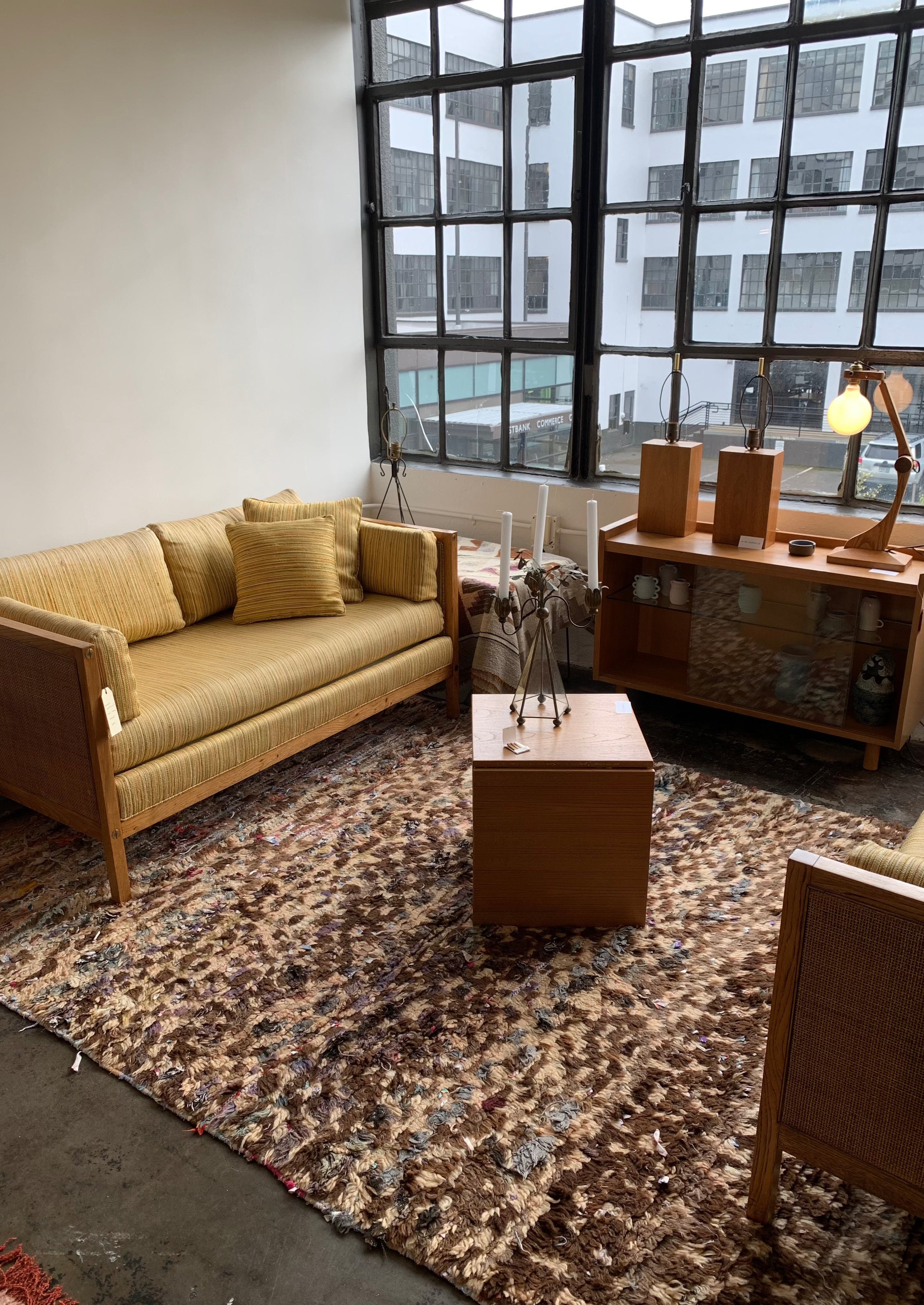 moroccan checkered rug in mcm stylish loft apartment with yellow sofa and wood furniture 