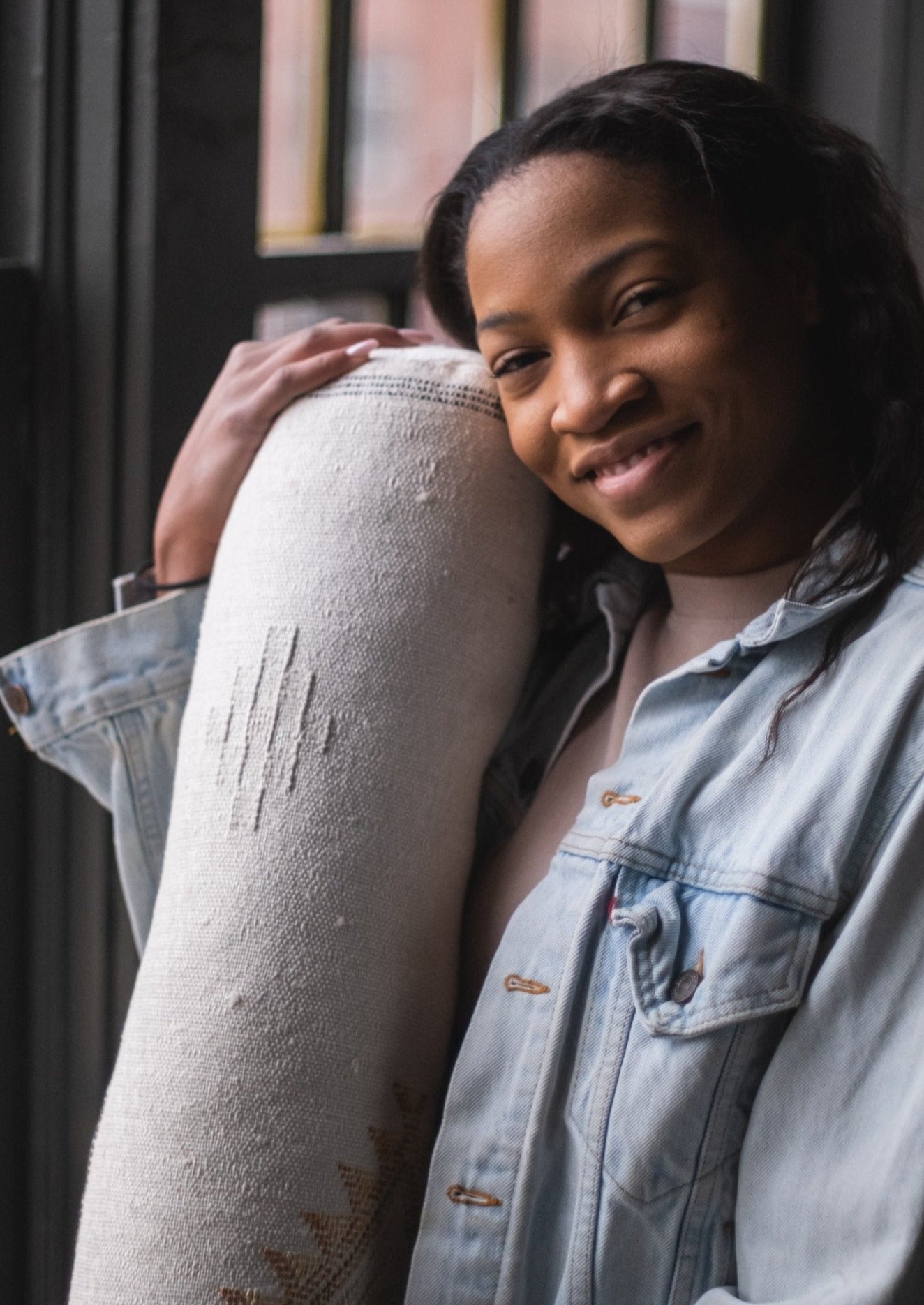 African American girl smiles knowing she is supporting global artists and is vegan friendly meaning no animals were harmed in the making of this cactus silk pillow